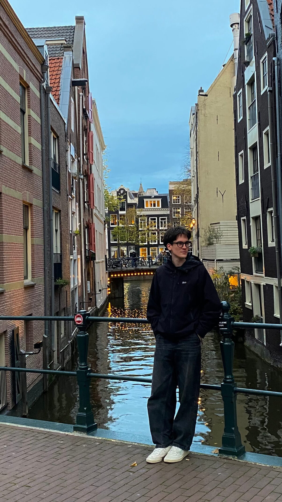 Albert Major on a bridge over an Amsterdam canal at dusk