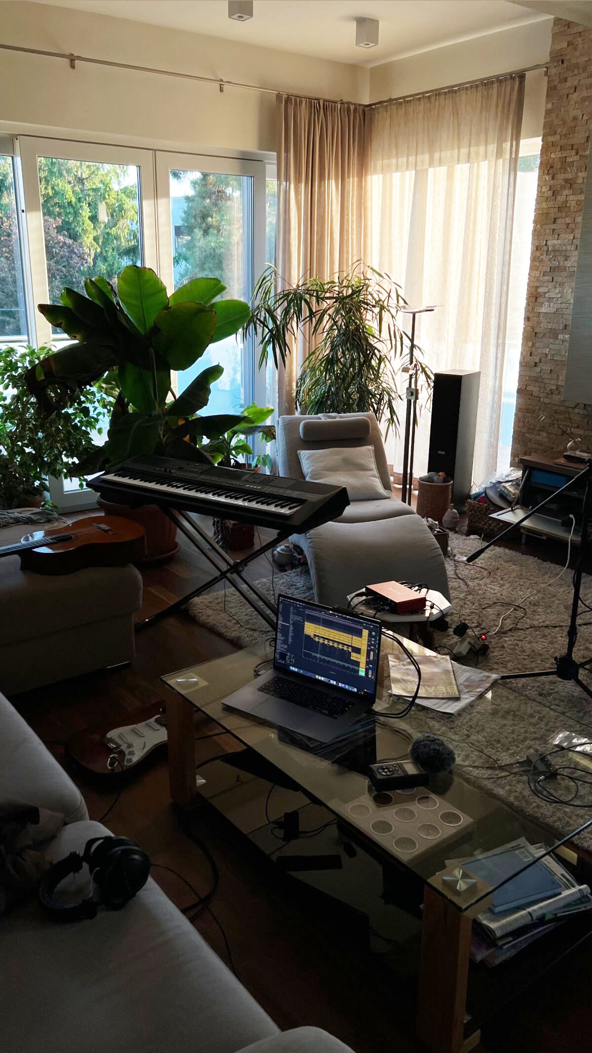 Home studio: stage keyboard, guitars, audio interface and a laptop running a session